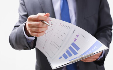 Wall Mural - Hand of businessman in suit filling and signing with silver pen partnership agreement form clipped to pad closeup. Management training course some important document team leader ambition concept