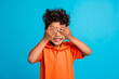 Photo of sweet adorable kid boy close eyes playing hide and seek with friends isolated blue color background