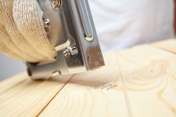 Wall Mural - Male installer using stapler for wooden plank