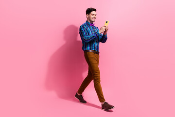 Canvas Print - Full length photo of cheerful guy using apple iphone 15 when texting girlfriend invite her date at cafe isolated on pink color background