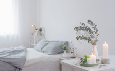 Wall Mural - burning candles and eucalyptus in  vase in white bedroom