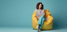 Happy Young Woman Sitting In Soft Chair Bag Isolated On Flat Background With Copy Space, Modern Minimal Style Banner Template. 