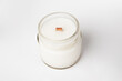 natural candle in a glass jar made of coconut wax with wooden wick on a white background