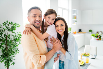 Canvas Print - Photo of cute adorable dad mom small daughter embracing enjoying morning time together indoors home kitchen