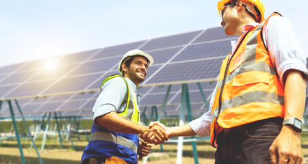 Wall Mural - Caucasian male architect and Asian engineer electrician shaking hands working colleagues team believing positive approach planning solar power project solar panels success developing energy industry.