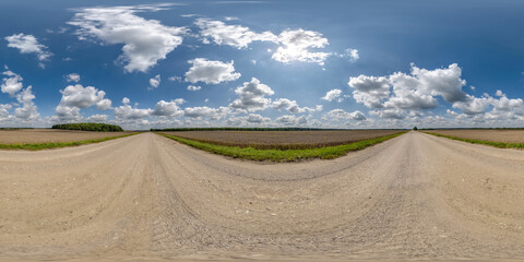 Wall Mural - 360 hdri panorama on wet gravel road with marks from car or tractor tires with clouds on blue sky in