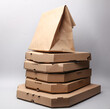 A stack of pizza cardboard boxes with a craft package on a gray background. Delivery, takeaway food