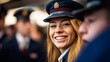 Young blonde woman in blue hat smiling at lively gathering. military or service or militia or police officer or student at university, police school. fictional