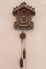 Historical wooden wall clock with pendulum