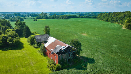 Wall Mural - Soybean farm with brown barn and red barn with partially blown off roof aerial