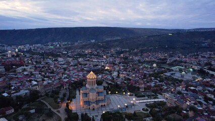 Wall Mural - 4k aerial tbilisi city footage just before sunrise with city lights and blue clouds in the sky