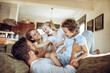 © Geber86 - Loving young family playing on the couch together at home