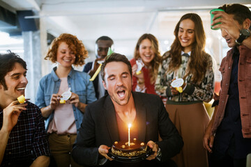 Wall Mural - Young businessman celebrating his birthday with colleagues in a modern office