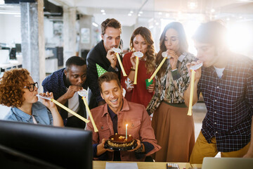 Wall Mural - Young businessman celebrating his birthday with colleagues in a modern office