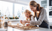 A Mother And Daughter Baking Festive Christmas Cookies Together At Home During The Holidays