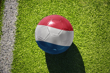 football ball with the flag of luxembourg on the green field near the white line