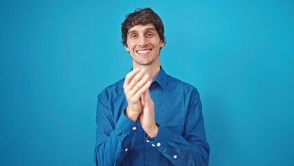 Poster - Young hispanic man smiling confident clapping hands over isolated blue background