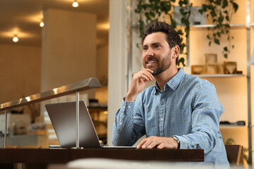 Poster - Man with laptop at table in cafe