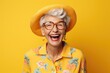 © InfiniteStudio - portrait of a cheerful smiling elderly grandmother in glasses on a yellow background