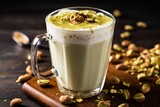 Detailed shot of a creamy pistachio latte topped with crushed nuts in a clear glass
