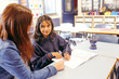 © Austockphoto - Aboriginal female school teacher sitting with her student in the classroom