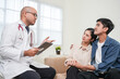 © BJ Day Stock - Male doctor giving test result to asian couple patient with tablet. They feeling stressed after received bad news from the doctor in medical office, hospital, clinic or home.