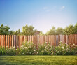 green grass lawn, flowers and wooden fence in spring backyard garden
