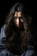 © Rainbow Kuma - A depressed Asian young woman stood in the darkness with his head in his hands