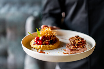 Wall Mural - waiter or chef hold Duck fillet with hummus and cherry