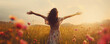  Happy carefree woman standing in the wildflower meadow with opened arms, back view

