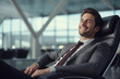 © Varitnan - a business man relax smile while seated on VIP chair in airport, rest and calm, Generative Ai.