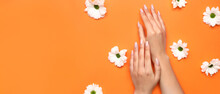 Female Hands With Beautiful Manicure And Flowers On Orange Background With Space For Text
