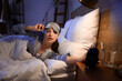 © Pixel-Shot - Young woman watching time in bedroom at night