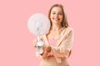 © Pixel-Shot - Young woman with electric fan on pink background