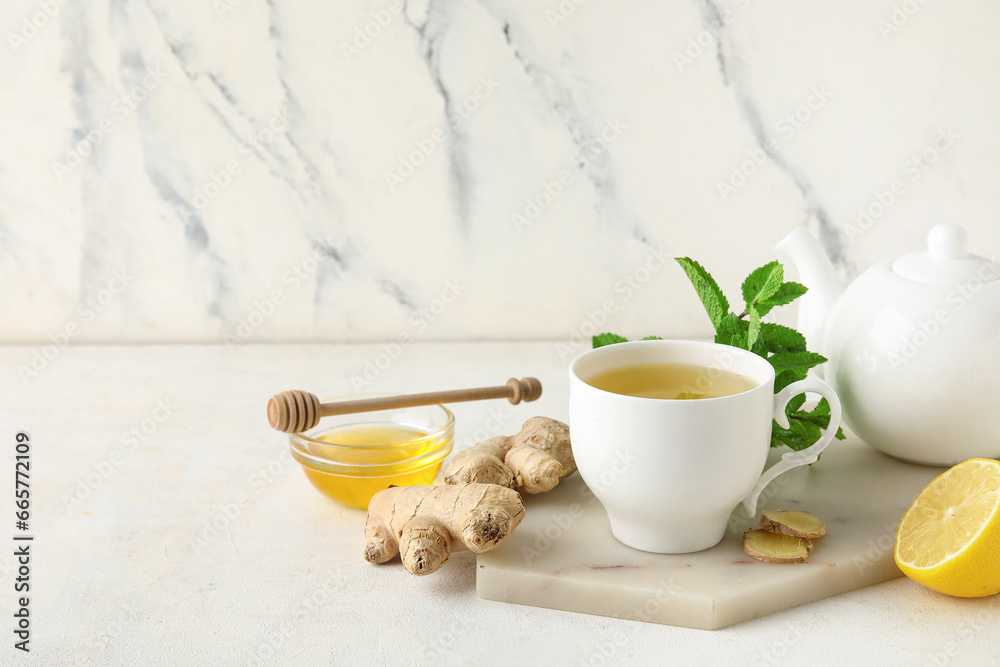 Cup of ginger tea and bowl with honey on white background