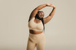 © gstockstudio - Attractive African plus size woman in underwear radiating self-love while standing