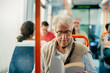 Senior man reading book while traveling with bus