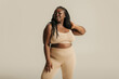 © gstockstudio - Attractive African curvy woman in underwear radiating self-love on studio background