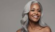 Smooth healthy skin and long gray hair on a beautiful black mature woman smiling happily in beauty and cosmetics skincare advertising concept