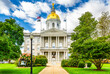 New Hampshire State House with the statue of Daniel Webster a prominent NH statesman, in Concord. The capitol houses the New Hampshire General Court, Governor, and Executive Council.