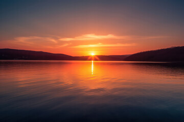 Wall Mural - a breathtaking sunset over a serene lake, with vibrant hues reflecting on the calm water, creating a