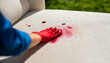 red wine stain being treated on a white sofa fabric