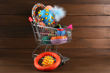 Wall Mural - Shopping cart with different pet shop goods on wooden background