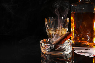 Canvas Print - Smoldering cigar, ashtray, playing cards and whiskey on black mirror surface. Space for text