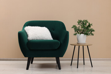 Canvas Print - Stylish armchair and side table with plant near beige wall indoors