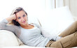 © Tabitha Rose/peopleimages.com - Woman, portrait and living room couch for lazy relax weekend, comfortable day off or cosy. Female person, face or tranquility solitude smile pose on apartment sofa for calm, positive mood in Canada