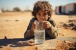 Thirsty Middle Eastern child in dirty clothes drinks water, witnessing the horror of war
