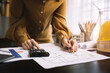 © NINENII - civil engineer or architect business useing calculator about calculate the cost with for working building plan design project in office.