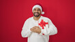 © Krakenimages.com - African american man holding christmas gift over isolated red background