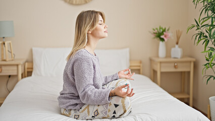 Sticker - Young blonde woman doing yoga exercise sitting on bed at bedroom